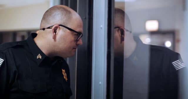Corrections officer looking out through a interior window