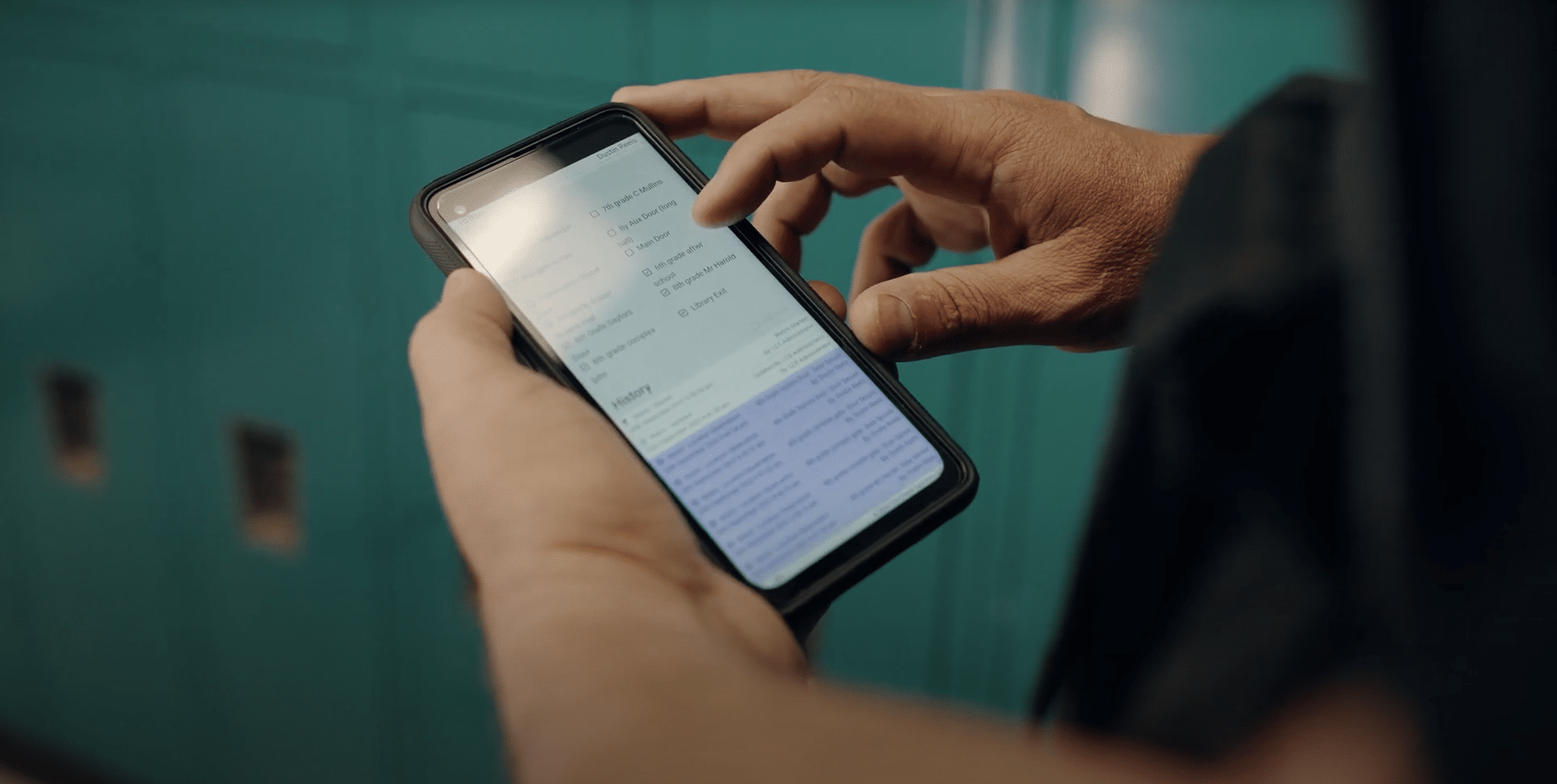 Man's hands holding device to monitor school door locks using Life Check Systems